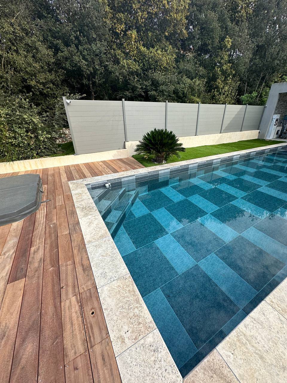 Réalisation sur mesure d’une piscine moderne en béton carrelage grand format avec un escalier d’ange 3 marches à Sanary sur mer dans le Var